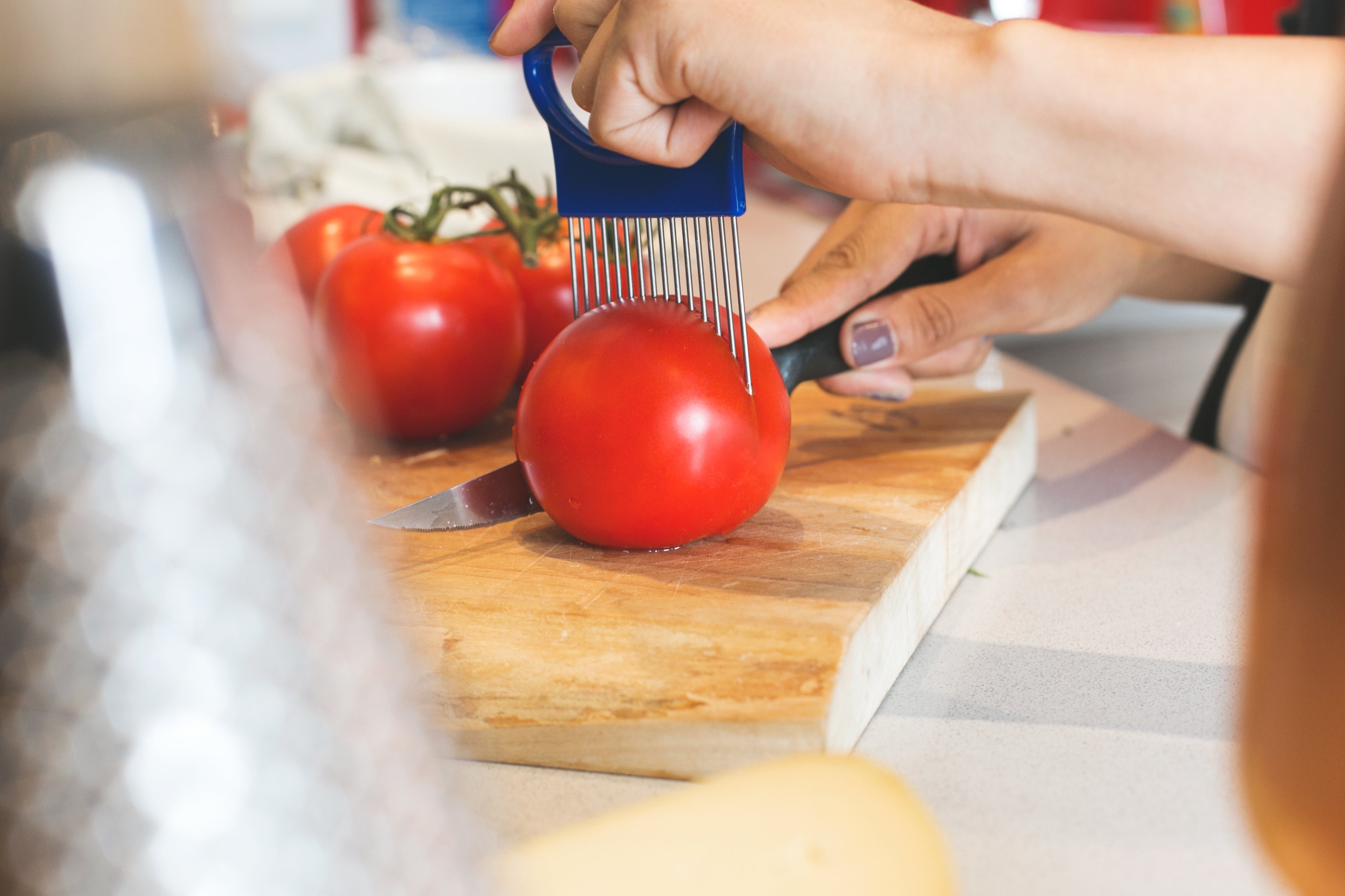 Person slicing fresh tomatoes in a clean kitchen — effortless meal prep