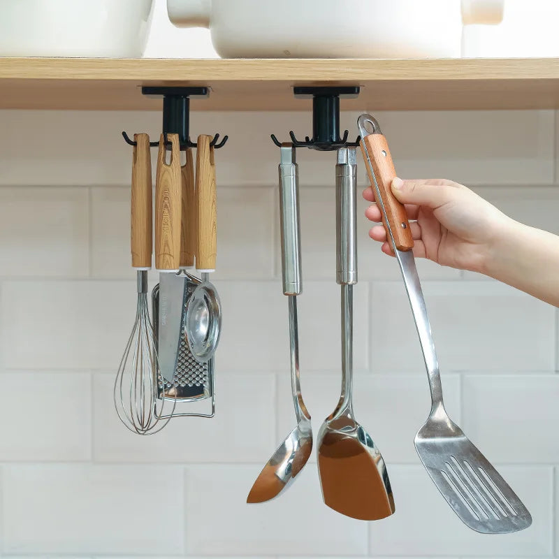 Rotating wall-mounted kitchen hooks rack holding utensils, spatulas, and a whisk under a cabinet shelf