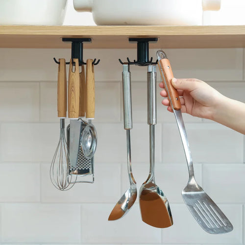 Rotating wall-mounted kitchen hooks rack holding utensils, spatulas, and a whisk under a cabinet shelf